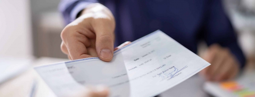 Businessperson Hands Giving Cheque To Other Person