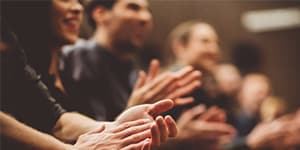 Blurred photo of people clapping during a speech or training session